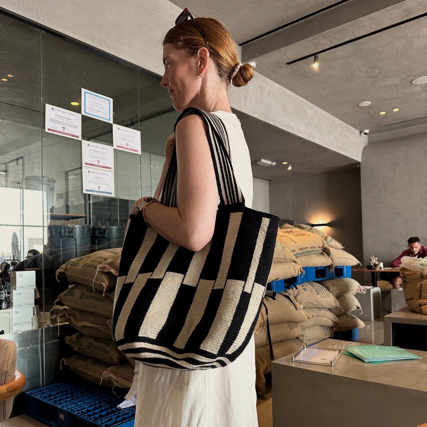 PALANACHI Stripped tote bag in beige and black by iiwa kashi, handcrafted by Wayuu artisans in La Guajira, Venezuela, made with pure cotton and 24K gold-plated silver logo.