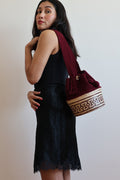 La Canasta Bag in burgundy by iiwa kashi, handcrafted by Wayuu artisans in Venezuela with cotton and caña brava, featuring 24K gold-plated logo.