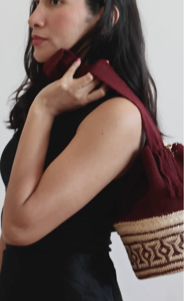 La Canasta Bag in burgundy by iiwa kashi, handcrafted by Wayuu artisans in Venezuela with cotton and caña brava, featuring 24K gold-plated logo.