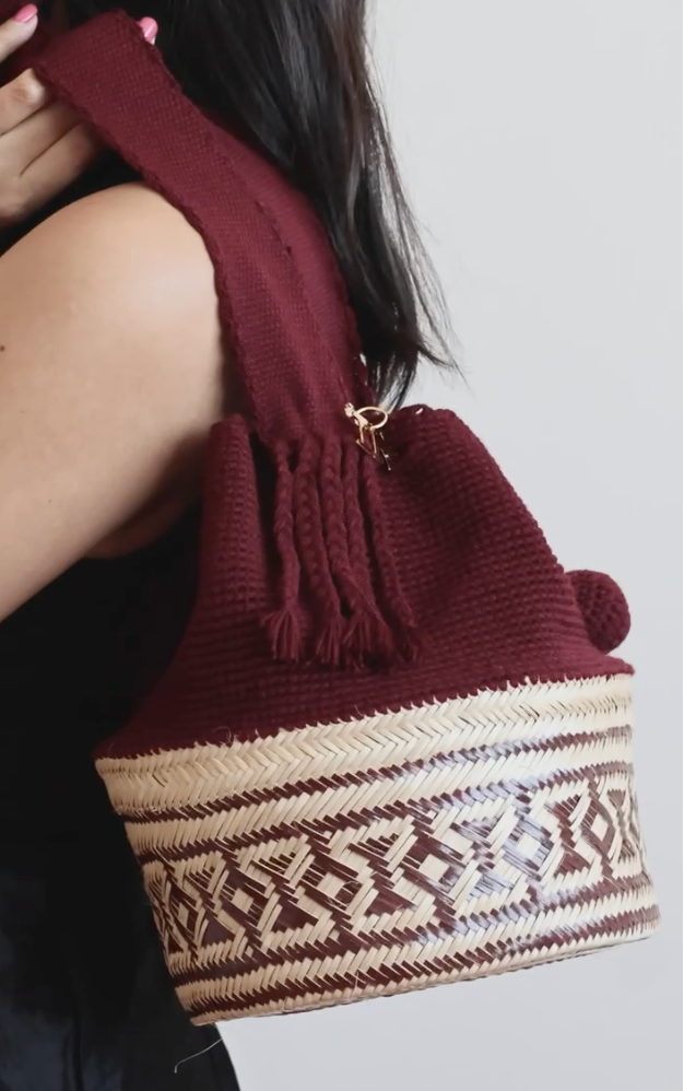 La Canasta Bag in burgundy by iiwa kashi, handcrafted by Wayuu artisans in Venezuela with cotton and caña brava, featuring 24K gold-plated logo.