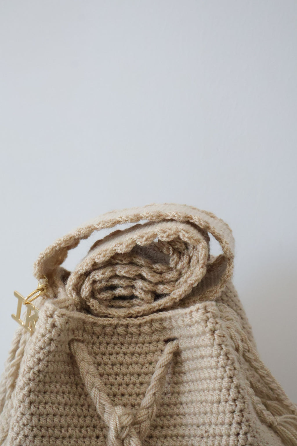 La Canasta Bag in beige by iiwa kashi, handcrafted by Wayuu artisans in Venezuela with cotton and caña brava, featuring 24K gold-plated logo.