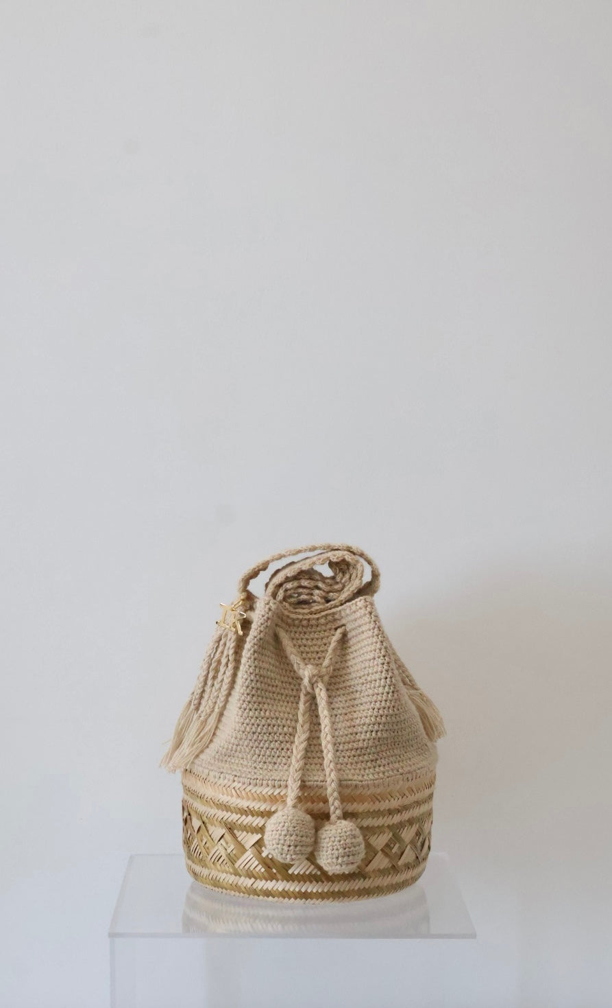 La Canasta Bag in beige by iiwa kashi, handcrafted by Wayuu artisans in Venezuela with cotton and caña brava, featuring 24K gold-plated logo.