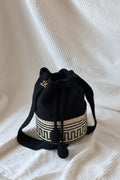 La Canasta Bag in black by iiwa kashi, handcrafted by Wayuu artisans in Venezuela with cotton and caña brava, featuring 24K gold-plated logo.