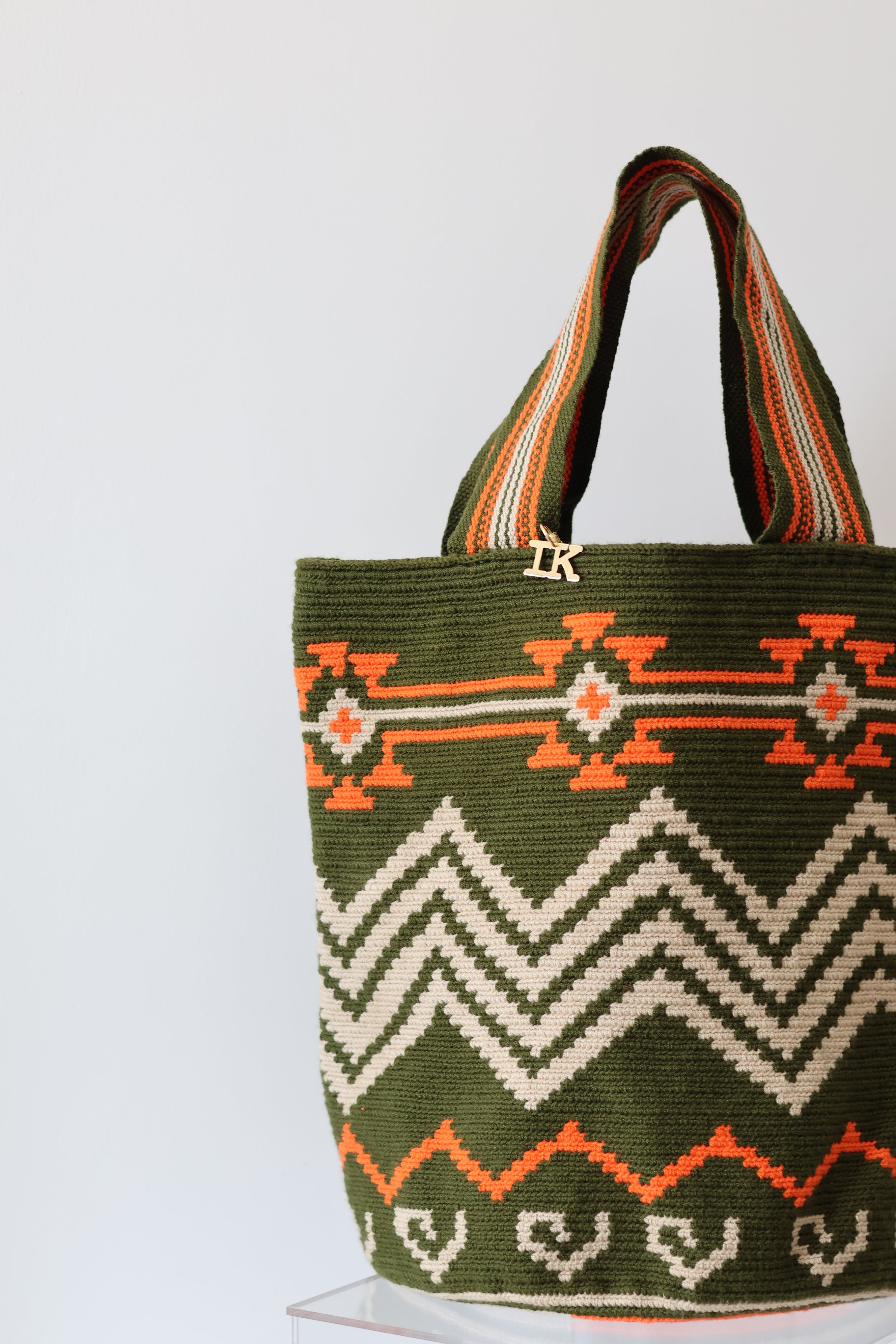 PALANACHI de la Tierra Wayuu Tote Bag in green and orange by iiwa kashi, handcrafted by Wayuu artisans from La Guajira, Venezuela, made with pure cotton and 24K gold-plated silver logo.