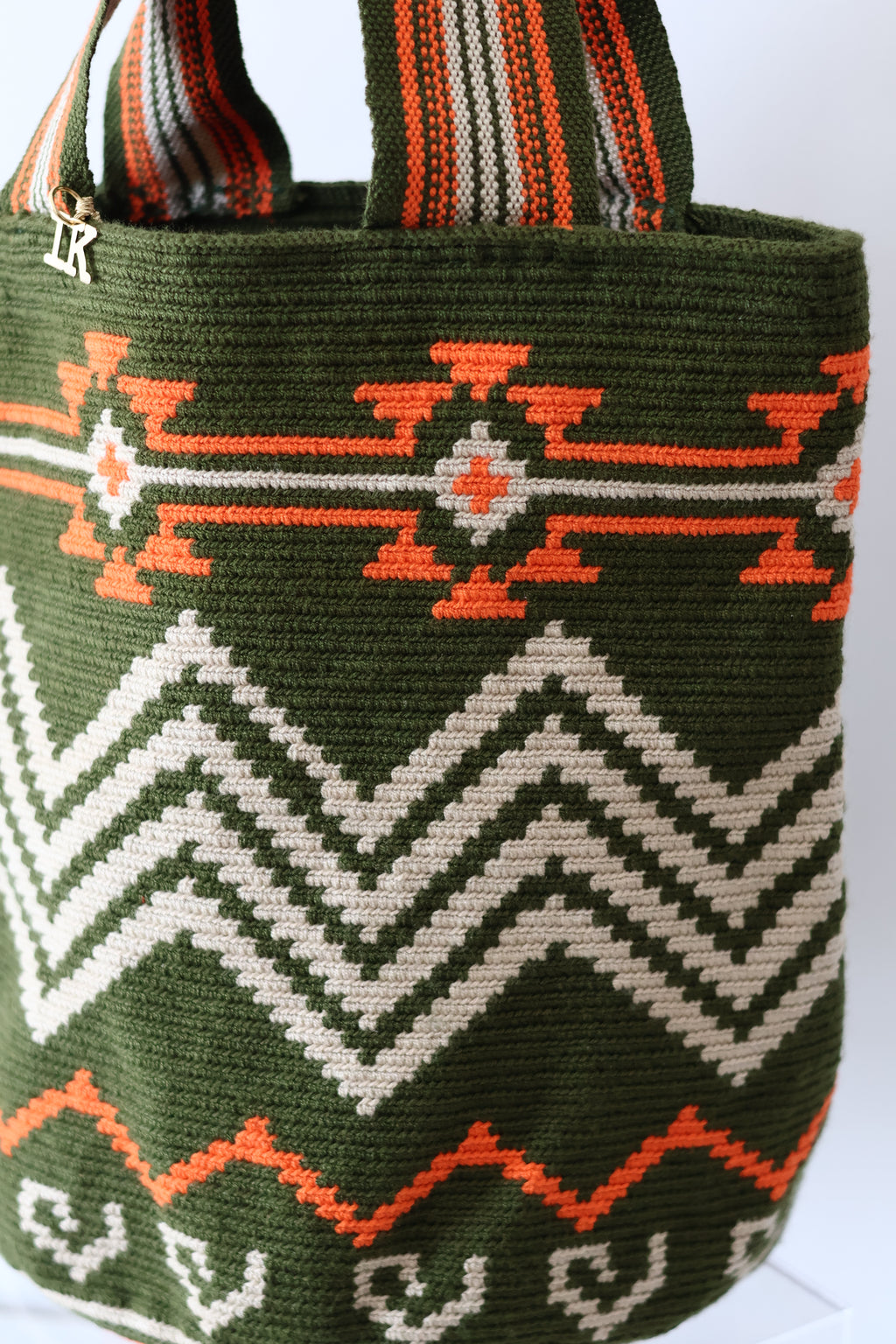 PALANACHI de la Tierra Wayuu Tote Bag in green and orange by iiwa kashi, handcrafted by Wayuu artisans from La Guajira, Venezuela, made with pure cotton and 24K gold-plated silver logo.